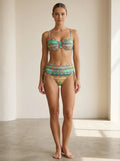 Driftly green ethnic print high-waisted bikini set with ruched sides and secure straps, in a minimalist studio setting with soft window light.