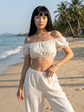 Woman wearing an off-white off-shoulder two-piece bikini set, on the beach