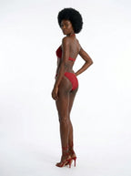 Woman wearing a red fringe bikini set, studio photography, back view