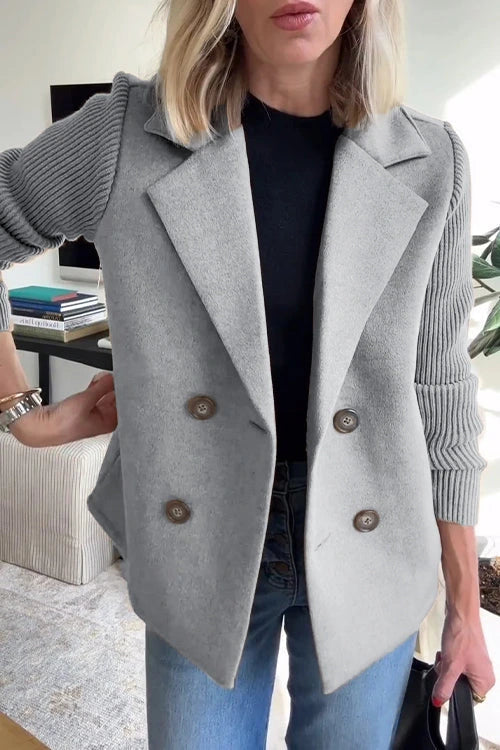Woman wearing a grey knit double-breasted blazer - studio photo