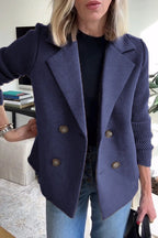 Woman wearing a navy knit double-breasted blazer - studio photo