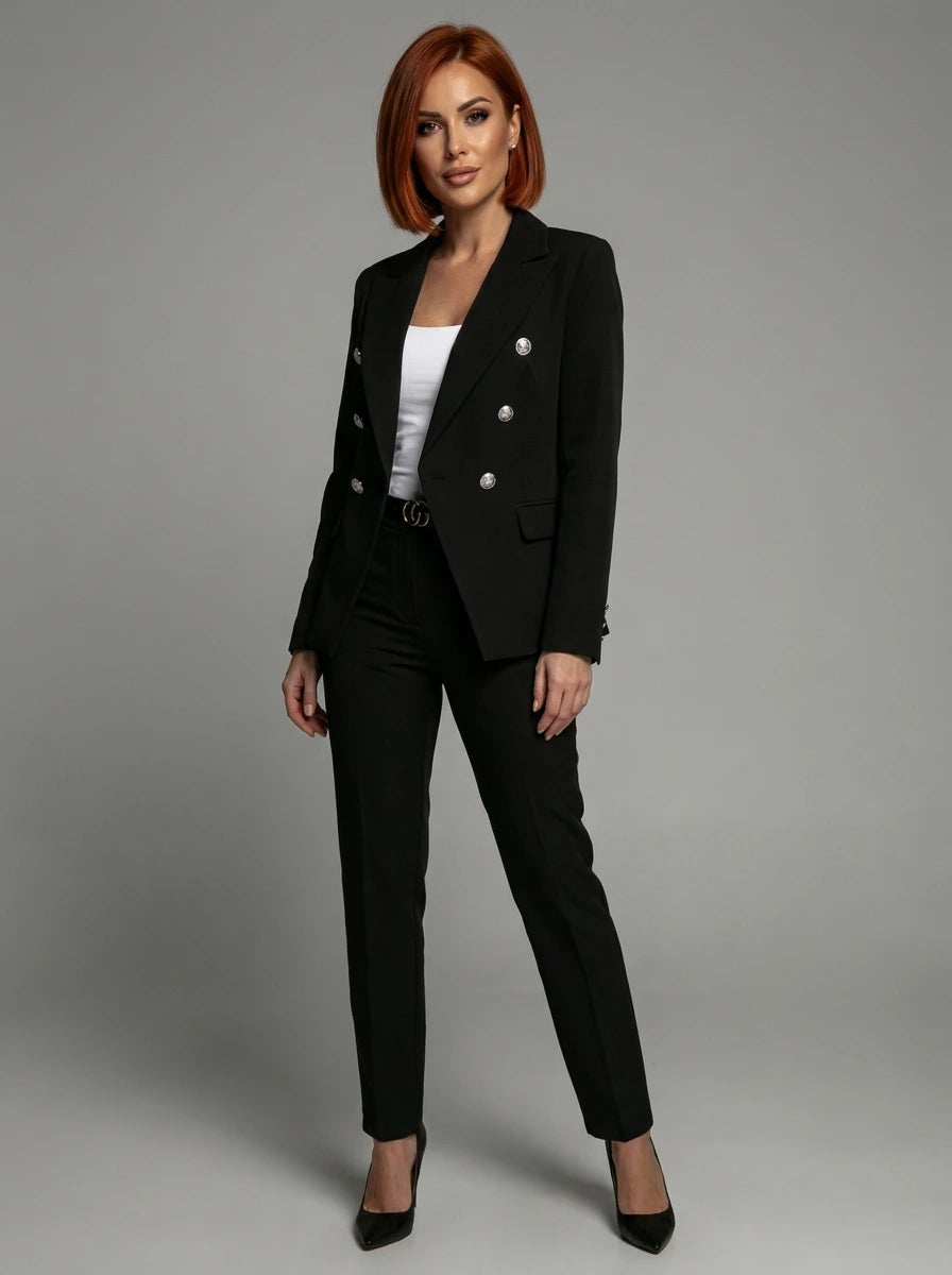 Woman wearing a black double-breasted tailored blazer and trouser set in a studio setting