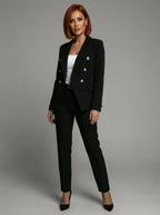 Woman wearing a black double-breasted tailored blazer and trouser set in a studio setting