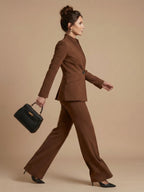 Woman wearing a brown structured stand collar tailored blazer - studio photo