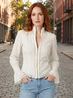 Woman wearing a white bohemian lace blouse with flared sleeves on a city street