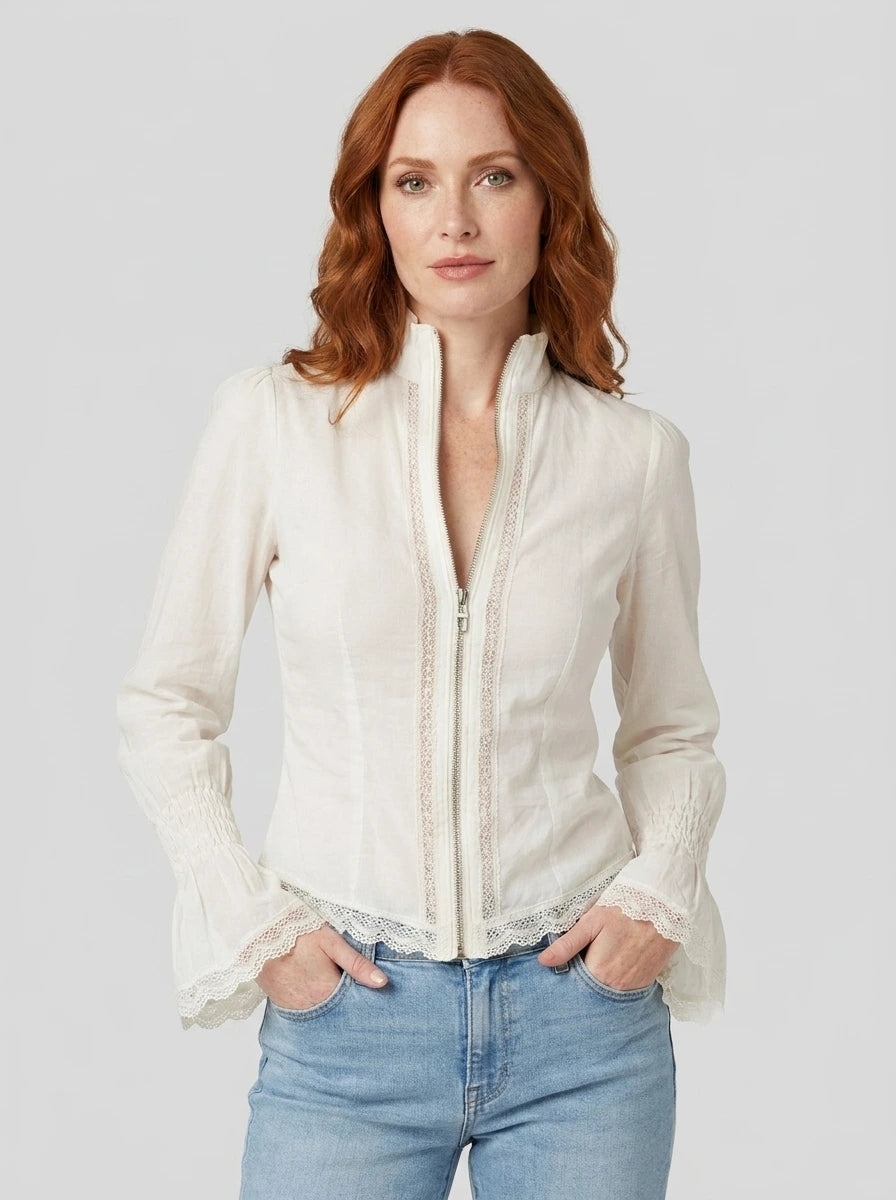 Woman wearing a white bohemian lace blouse with flared sleeves in a studio setting
