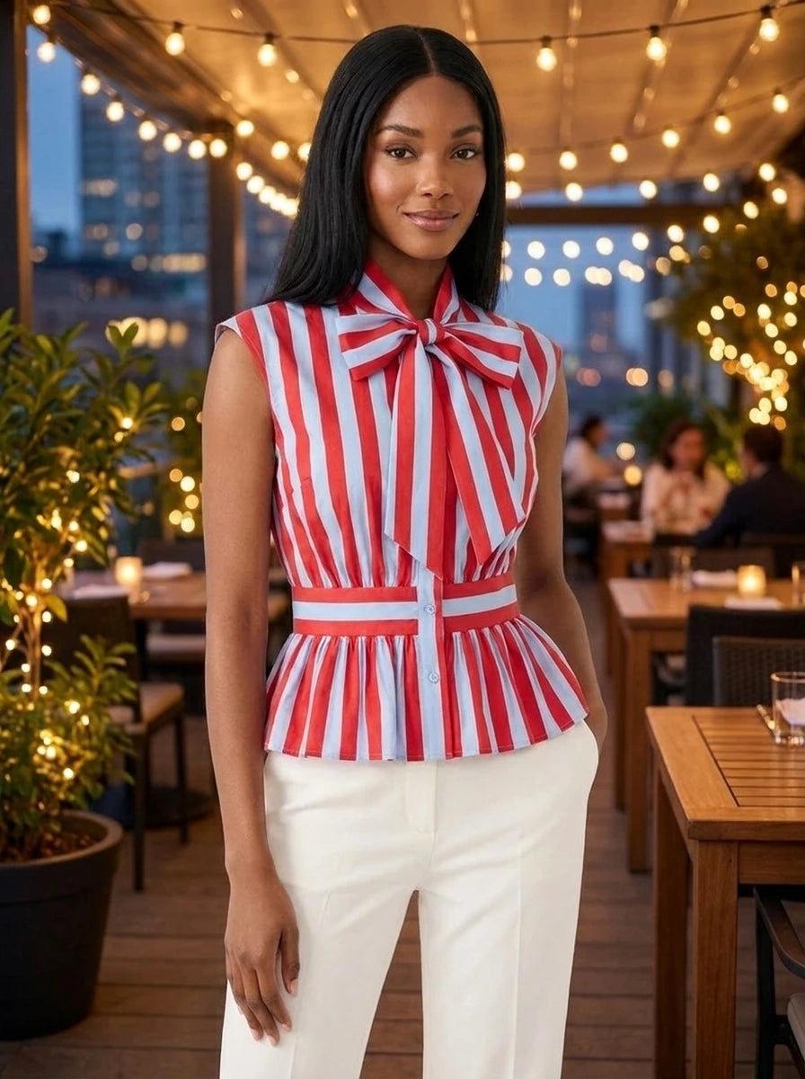 Woman wearing a red and light blue striped bowknot blouse on an outdoor restaurant terrace in the evening