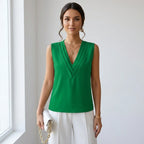 Driftly women's green sleeveless soft-touch blouse, styled with white wide-leg trousers in a minimalist studio setting.