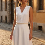 Driftly women's white sleeveless soft-touch blouse, styled with a white midi skirt on a European street at golden hour.