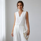 Driftly women's white sleeveless soft-touch blouse, styled with white wide-leg trousers in a minimalist studio setting.