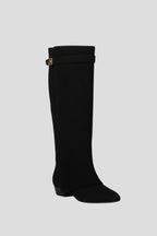 Woman wearing a black suede wide opening block heel boot - studio photo