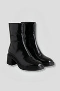 Woman wearing black block heel side zipper ankle boots - studio photo