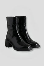 Woman wearing black block heel side zipper ankle boots - studio photo