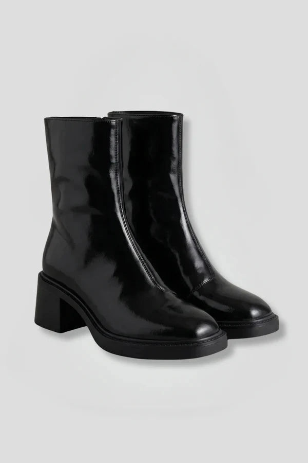 Woman wearing black block heel side zipper ankle boots - studio photo