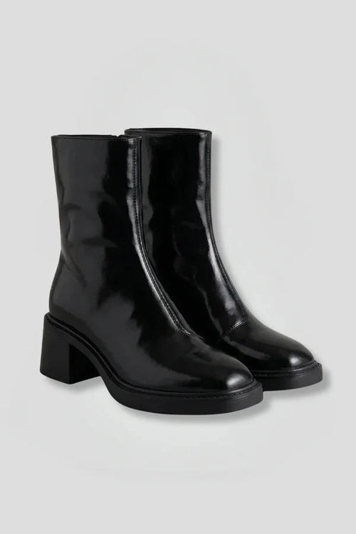 Woman wearing black block heel side zipper ankle boots - studio photo