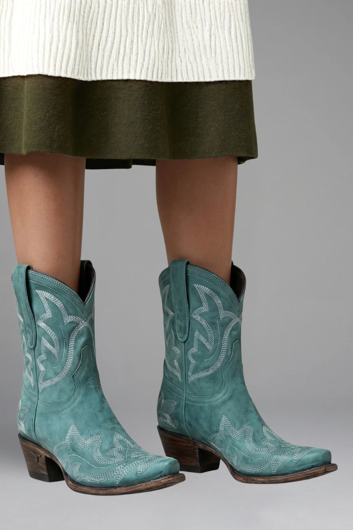 Woman wearing turquoise teal embroidered detailing all-season boots - studio photo