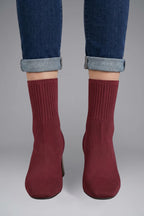 Woman wearing burgundy ribbed stretch ankle boots - lifestyle photo