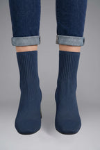 Woman wearing navy blue ribbed stretch ankle boots - lifestyle photo
