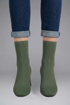 Woman wearing olive green ribbed stretch ankle boots - lifestyle photo
