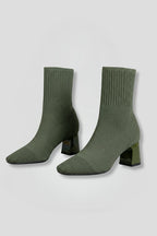 Woman wearing olive green ribbed stretch ankle boots - studio photo