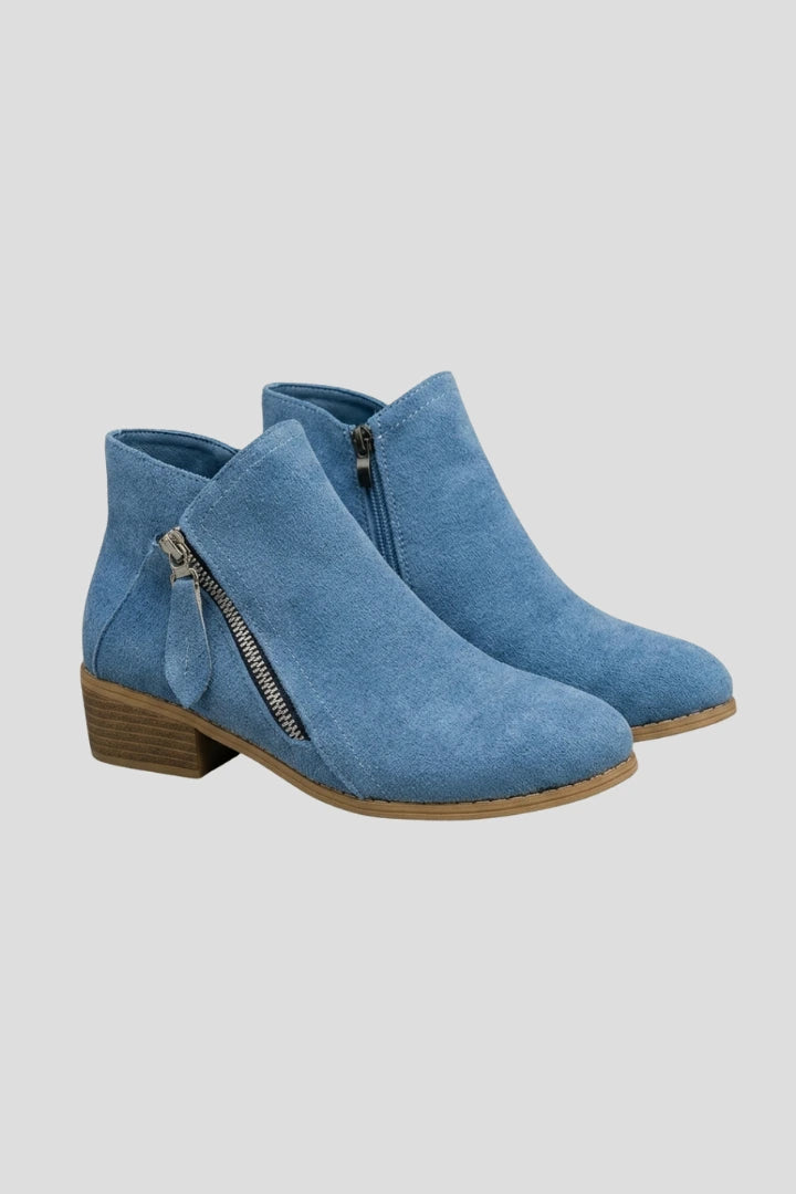 Woman wearing blue suede side zipper ankle boots - studio photo