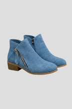 Woman wearing blue suede side zipper ankle boots - studio photo