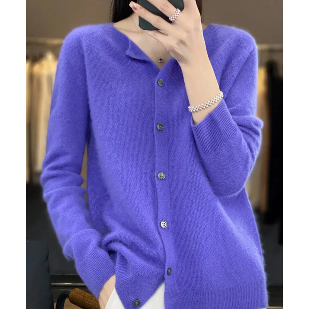 Woman wearing a dark blue wool cashmere button-up cardigan in a studio setting
