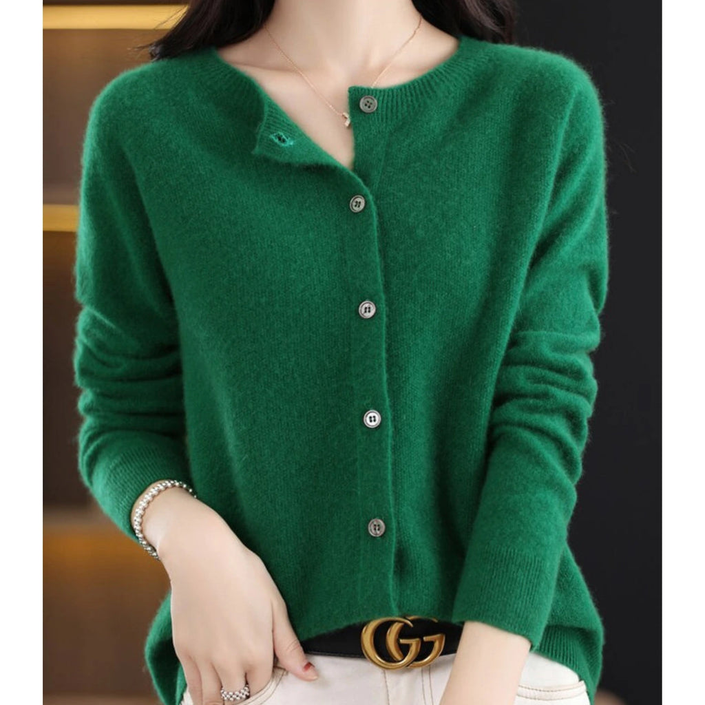 Woman wearing a dark green wool cashmere button-up cardigan in a studio setting