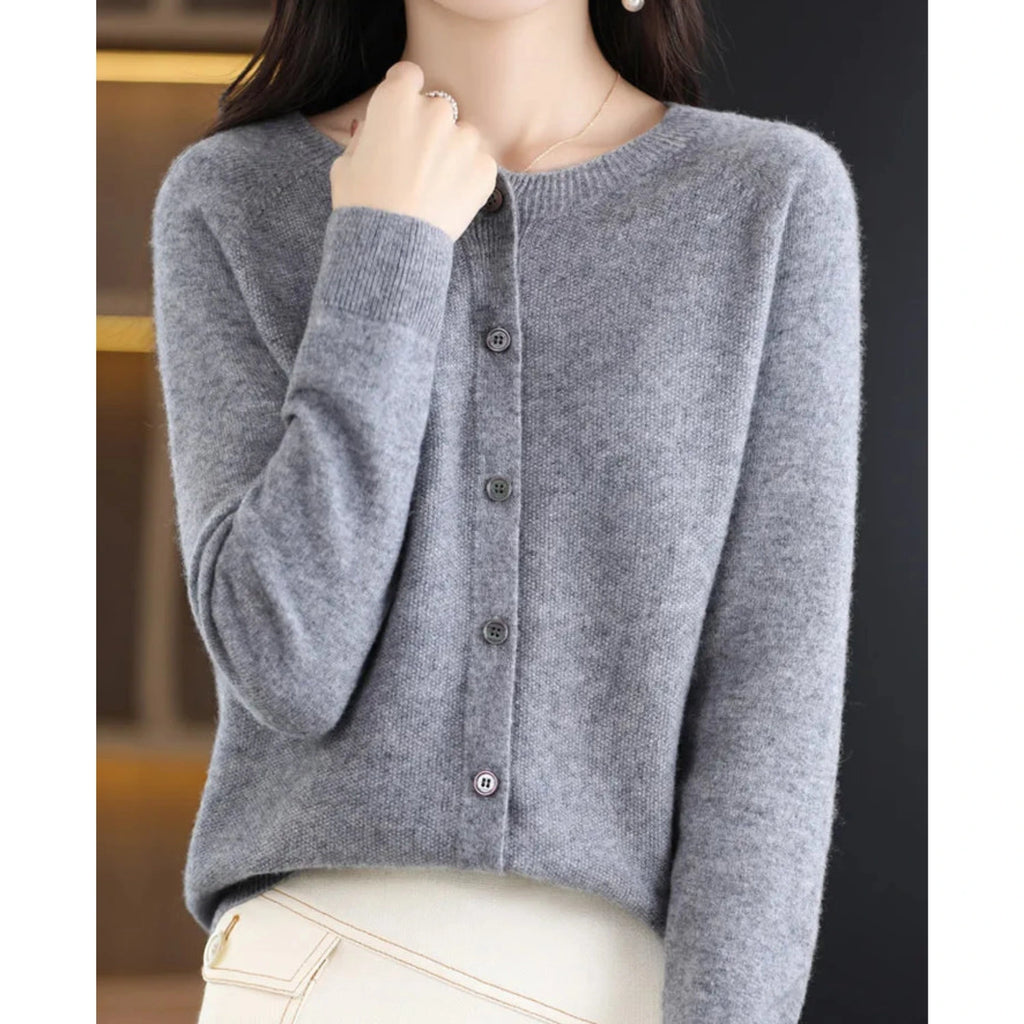 Woman wearing a grey wool cashmere button-up cardigan in a studio setting
