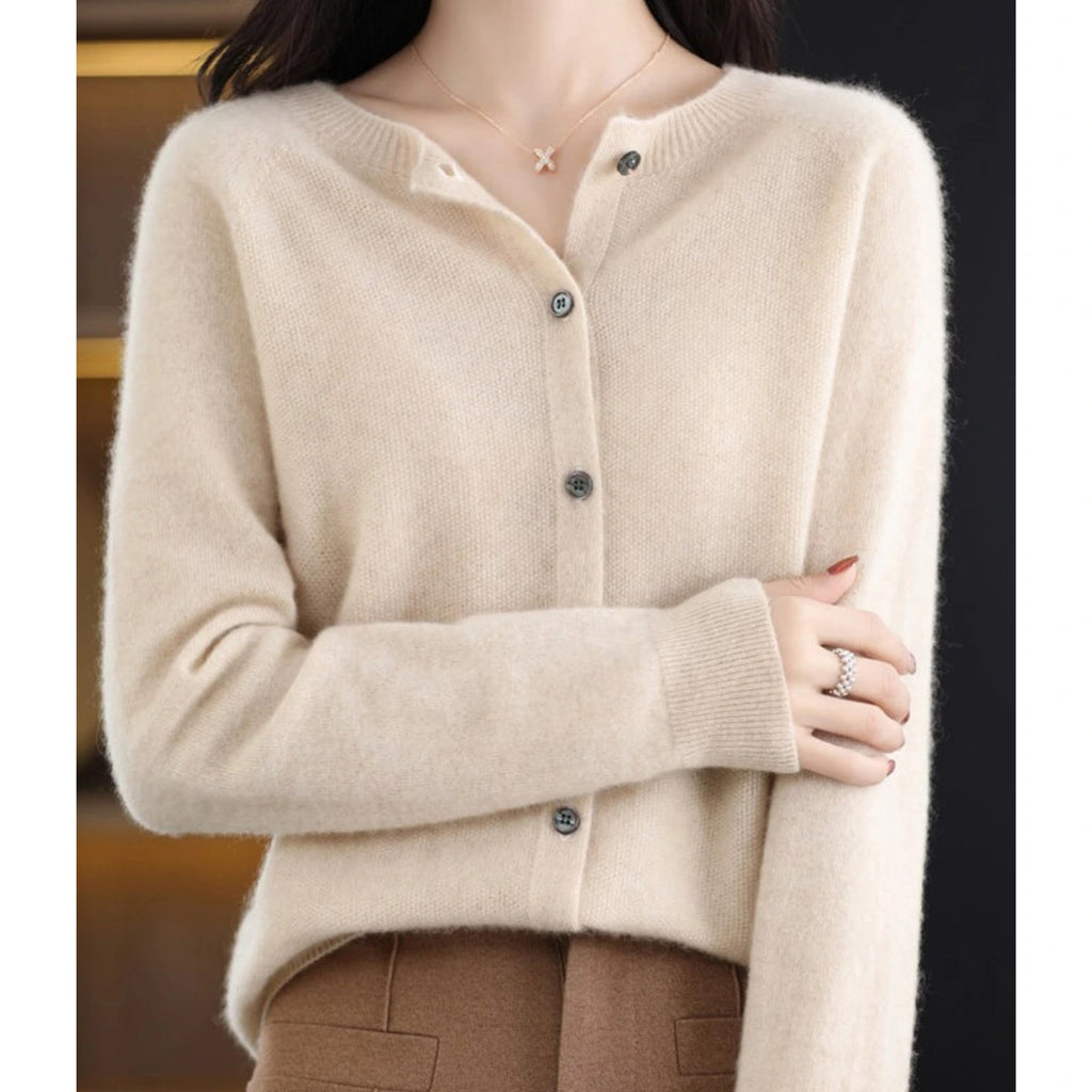 Woman wearing a khaki wool cashmere button-up cardigan in a studio setting