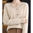 Woman wearing a khaki wool cashmere button-up cardigan in a studio setting