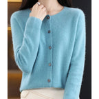 Woman wearing a light blue wool cashmere button-up cardigan in a studio setting