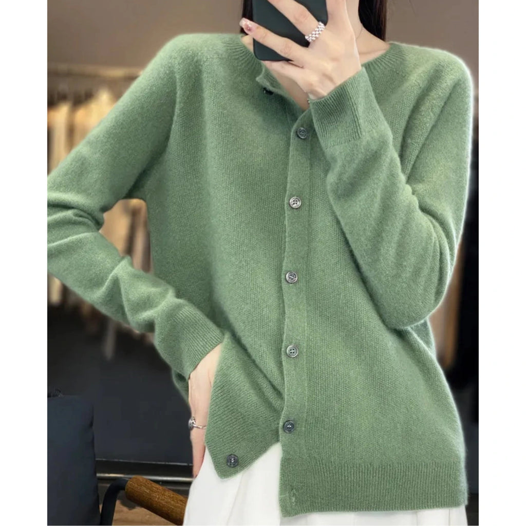 Woman wearing a light green wool cashmere button-up cardigan in a studio setting