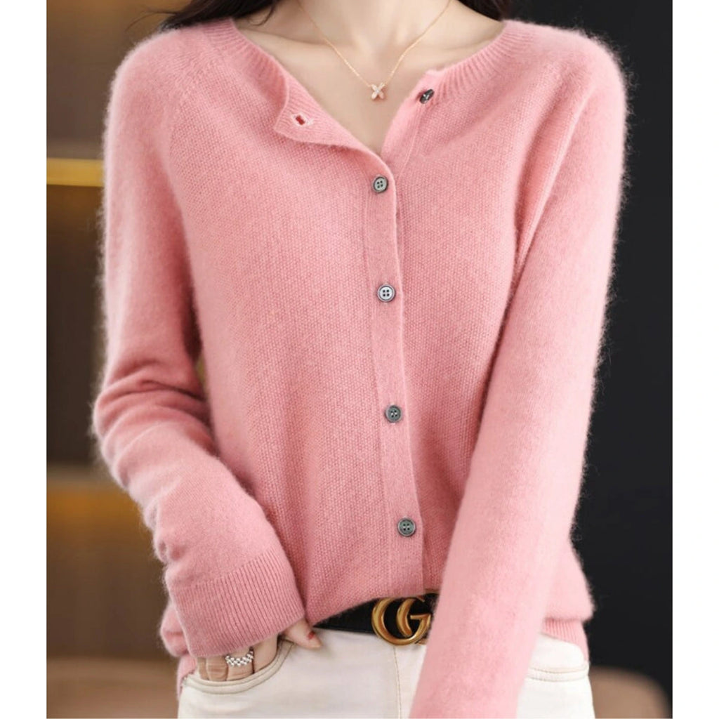 Woman wearing a light pink wool cashmere button-up cardigan in a studio setting