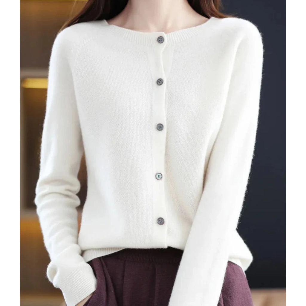Woman wearing a white wool cashmere button-up cardigan in a studio setting