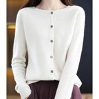 Woman wearing a white wool cashmere button-up cardigan in a studio setting