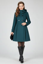 Woman wearing a green hooded double button-front coat - studio photo