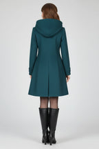 Woman wearing a navy blue hooded double button-front coat - studio photo