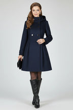 Woman wearing a navy blue hooded double button-front coat - studio photo