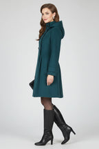 Woman wearing a navy blue hooded double button-front coat - studio photo