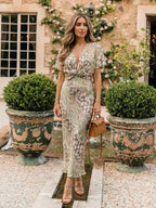 Woman wearing a gold abstract print v-neck twist-waist midi dress - editorial style photo