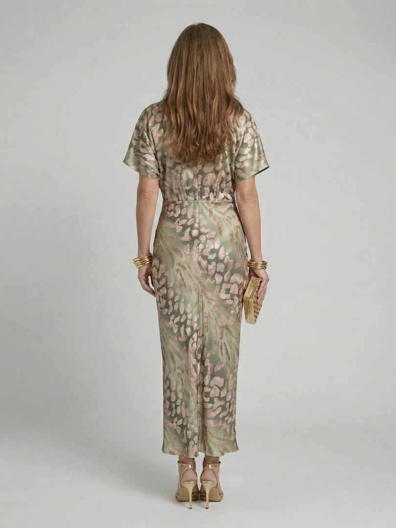 Woman wearing a gold abstract print v-neck twist-waist midi dress - studio photo