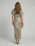 Woman wearing a gold abstract print v-neck twist-waist midi dress - studio photo