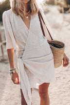 Woman wearing a beige blend wrap mini dress - outdoor lifestyle photo