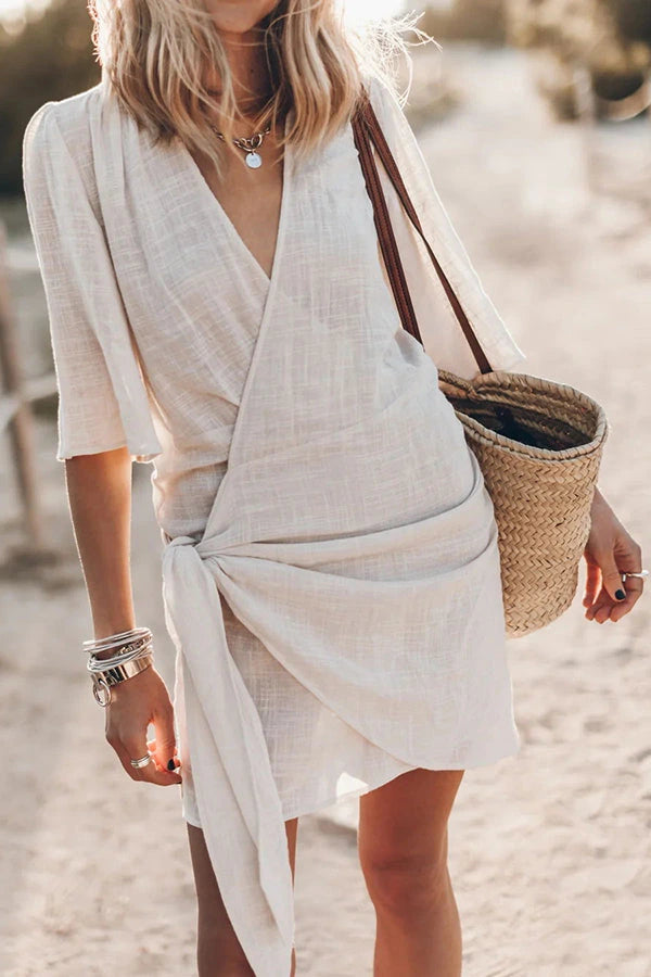 Woman wearing a beige blend wrap mini dress - outdoor lifestyle photo