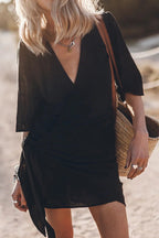 Woman wearing a black blend wrap mini dress - studio photo