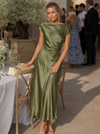 Woman wearing a dark green boat neck short sleeve midi dress - editorial style photo
