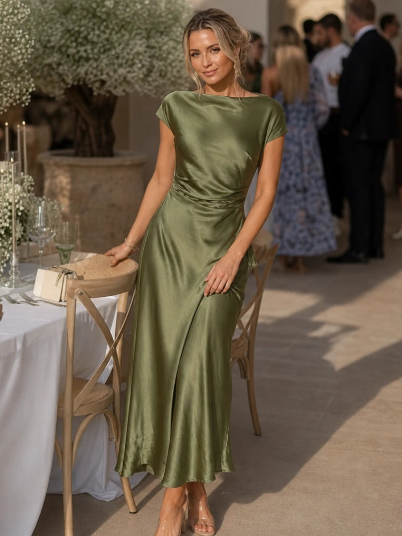 Woman wearing a dark green boat neck short sleeve midi dress - editorial style photo
