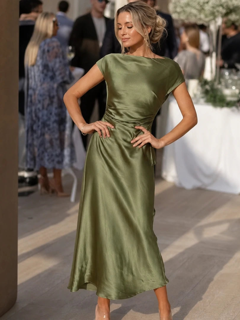 Woman wearing a green boat neck short sleeve midi dress - editorial style photo