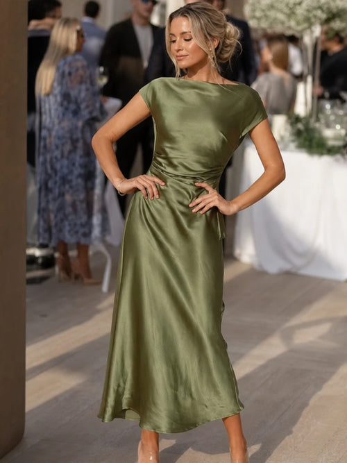 Woman wearing a green boat neck short sleeve midi dress - editorial style photo